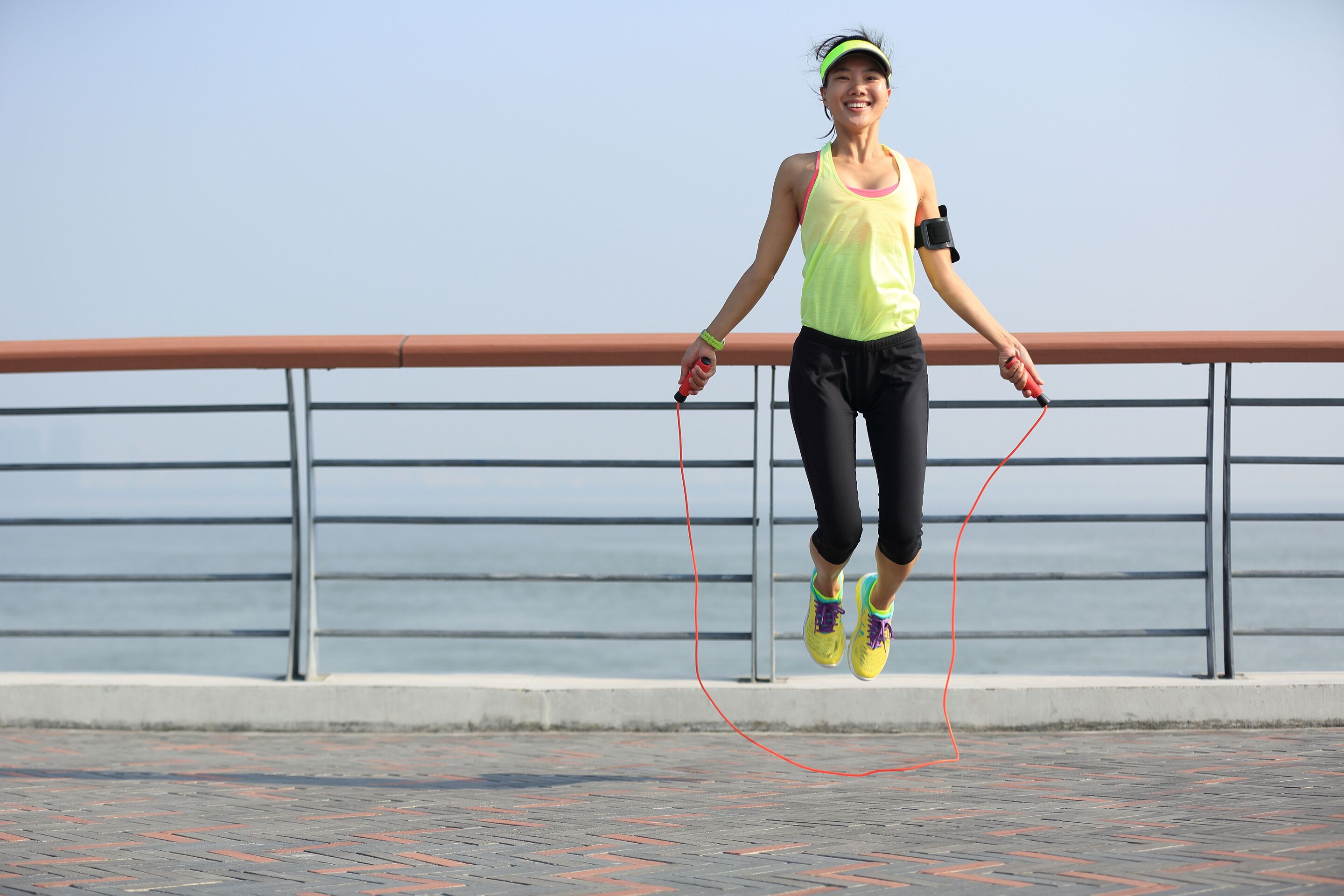 A fit Asian woman skipping rope outdoors