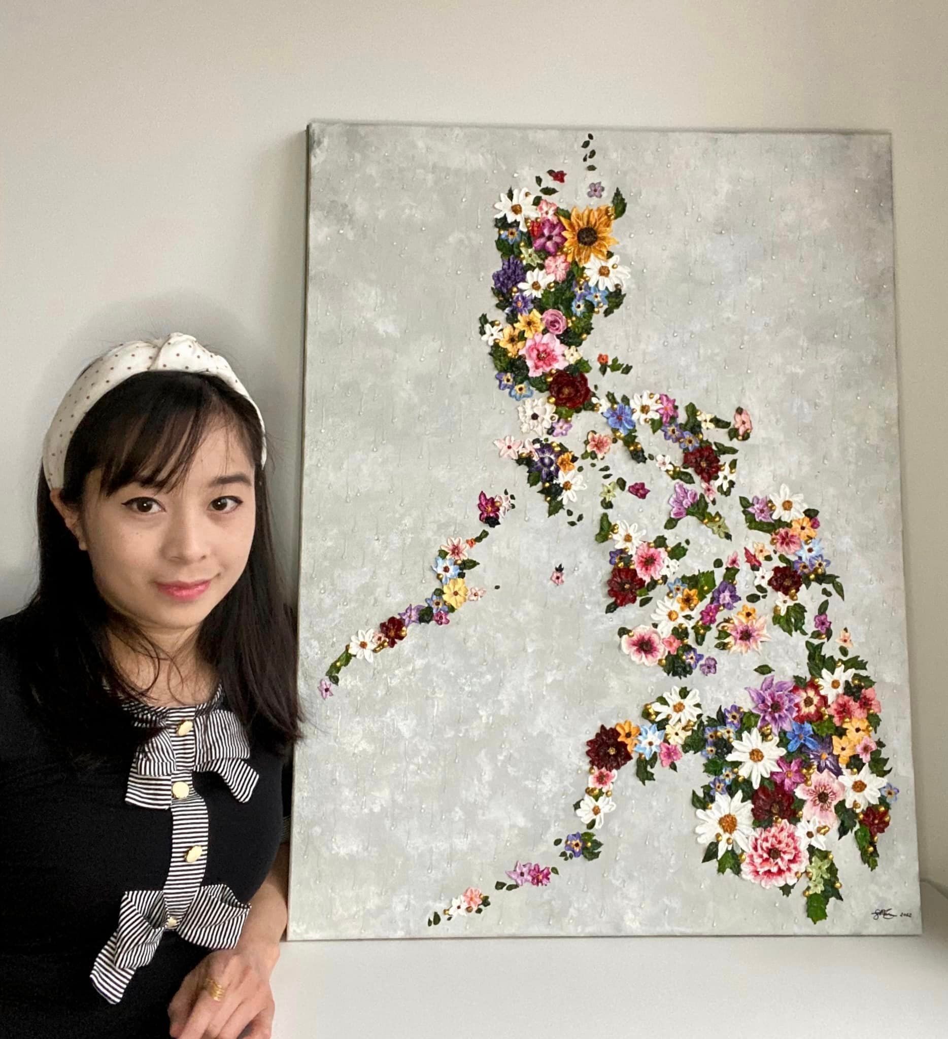 Filipino female artist Sheila Paren posing with her artwork. 