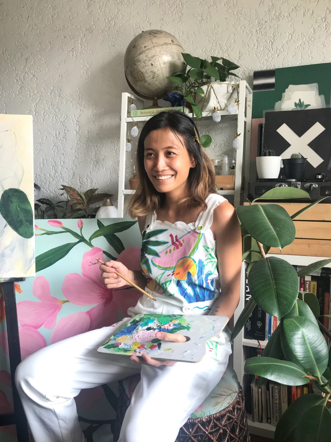 Artist Anina Rubio holding a palette and painting.