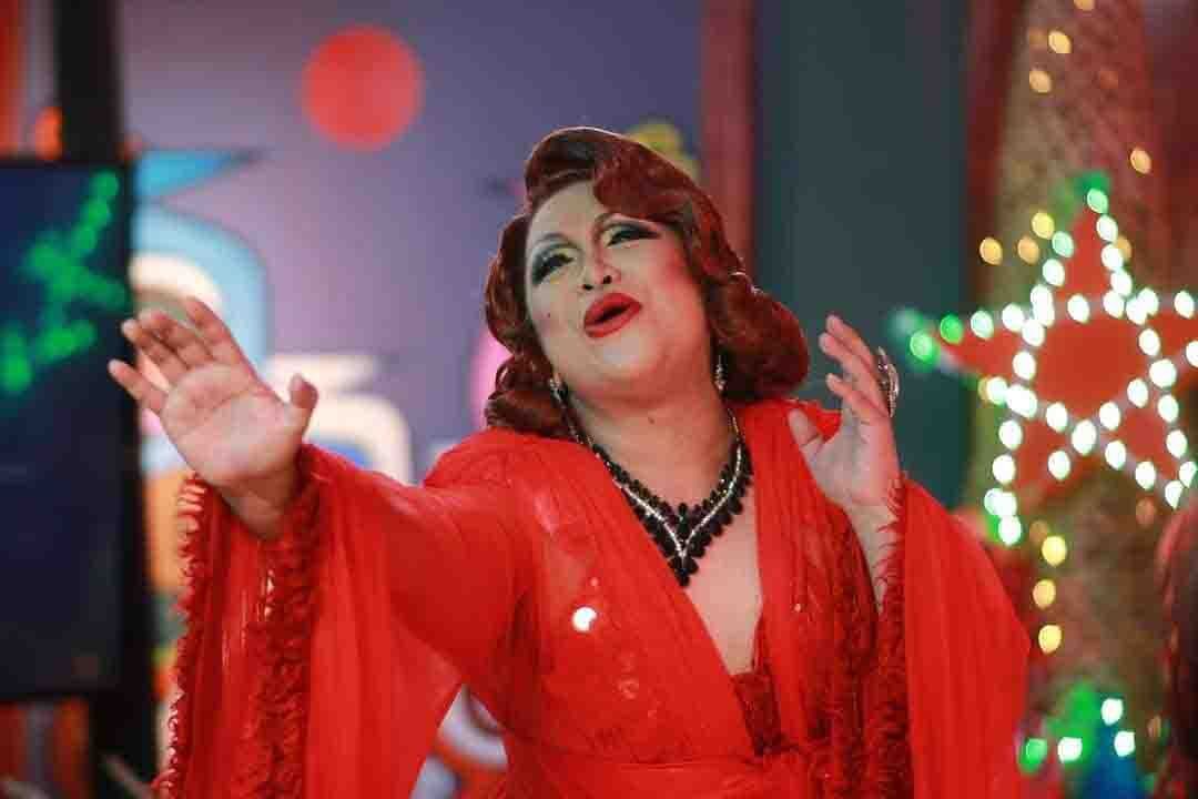 A drag queen wearing a red gown