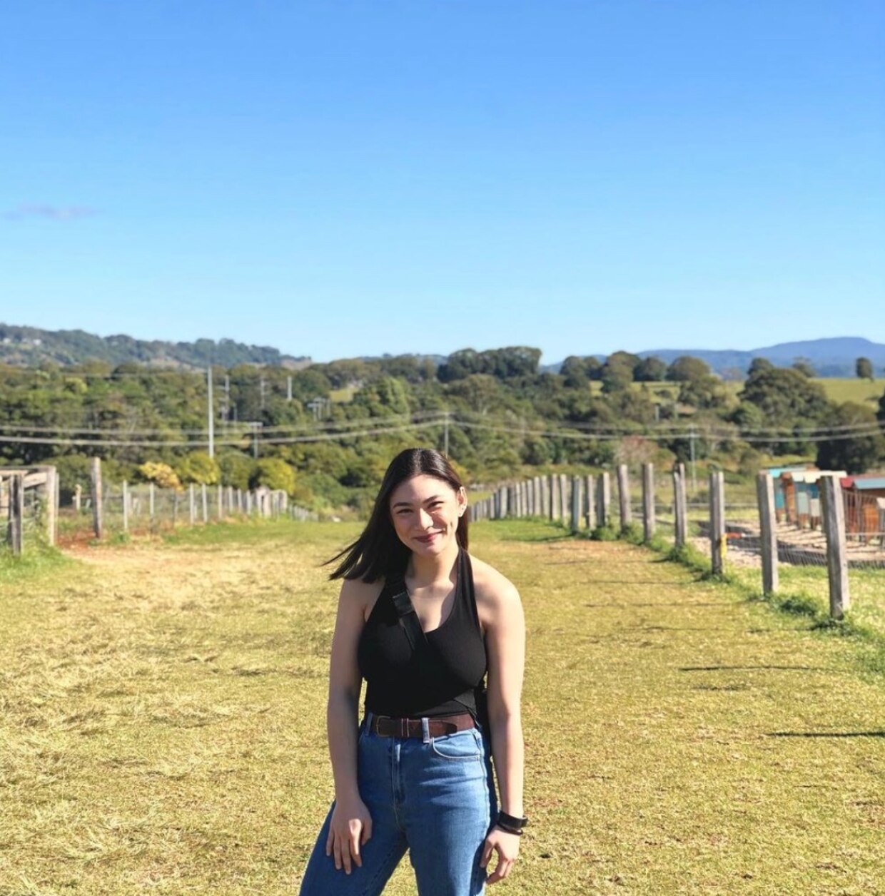 Asian woman smiling against a mountain view.