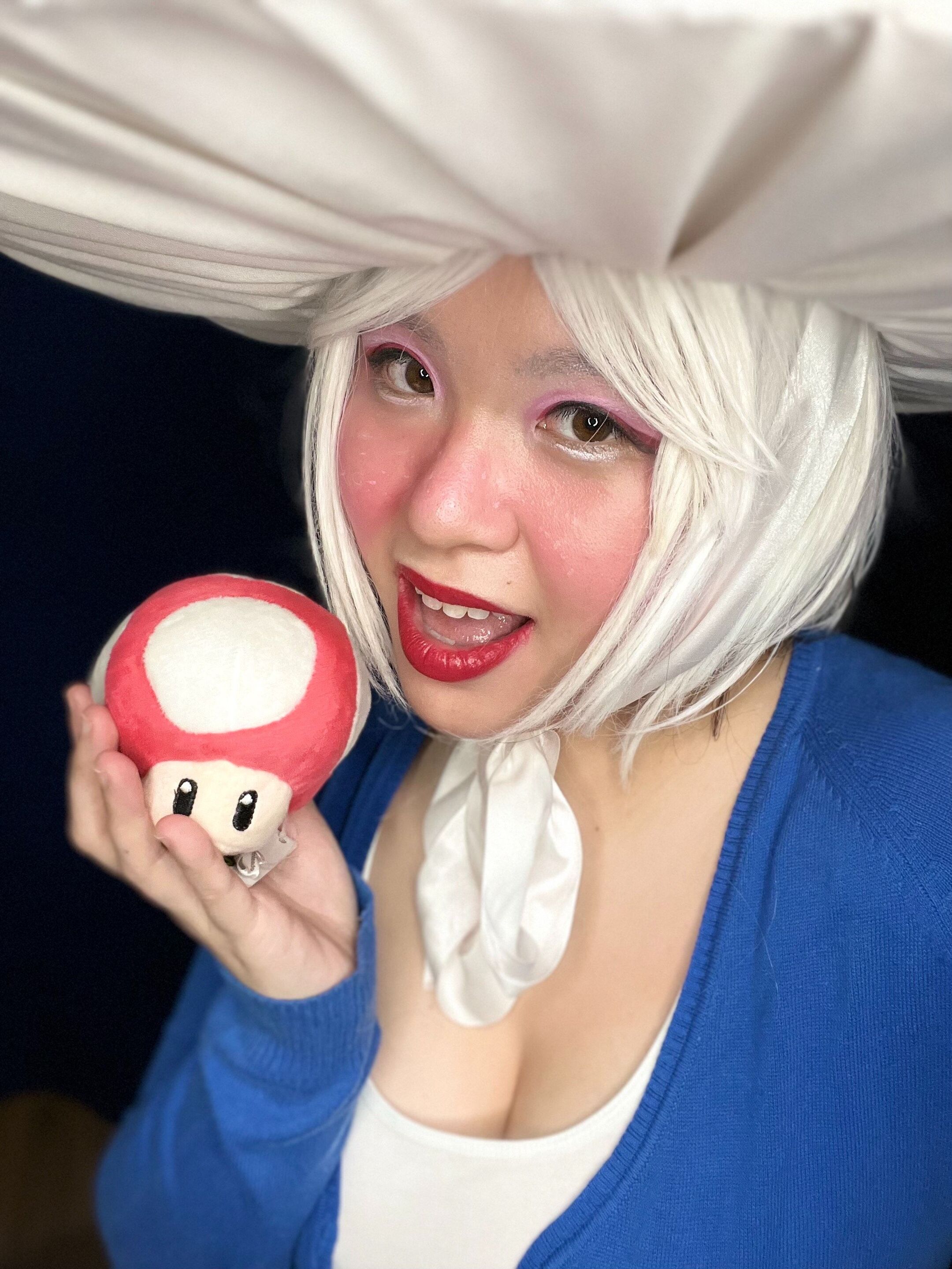A selfie of woman with a short blonde wig cosplaying as Toad from Mario Bros.