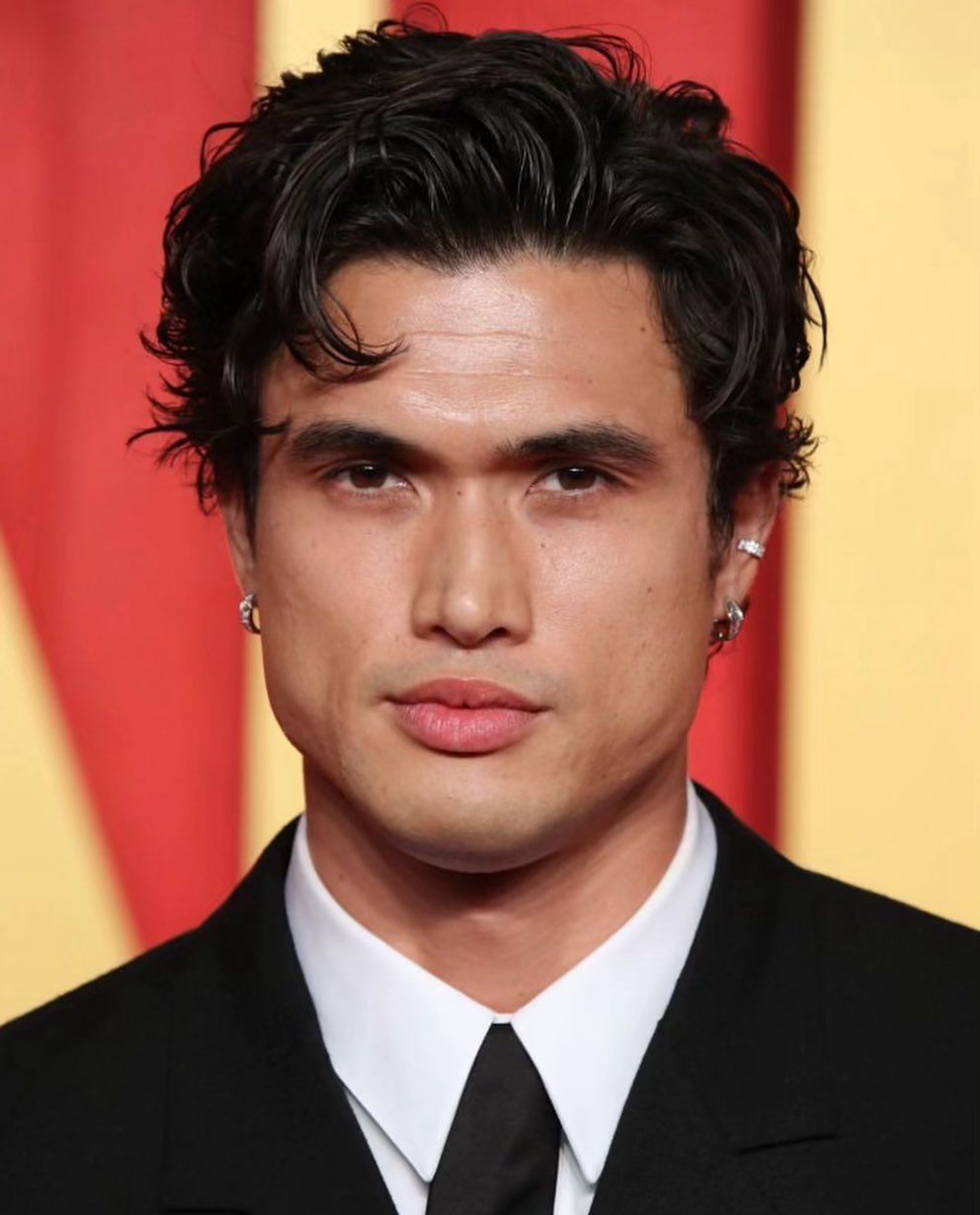 A close-up shot of Charles Melton in a suit.