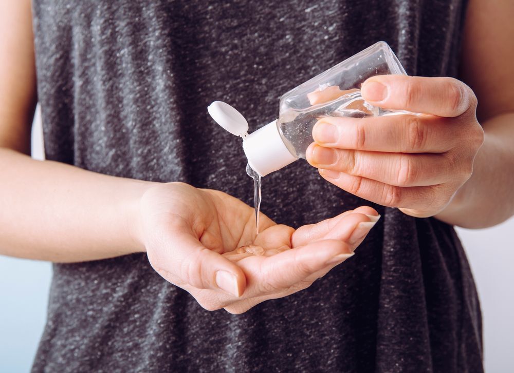 A woman holding a hand sanitizer