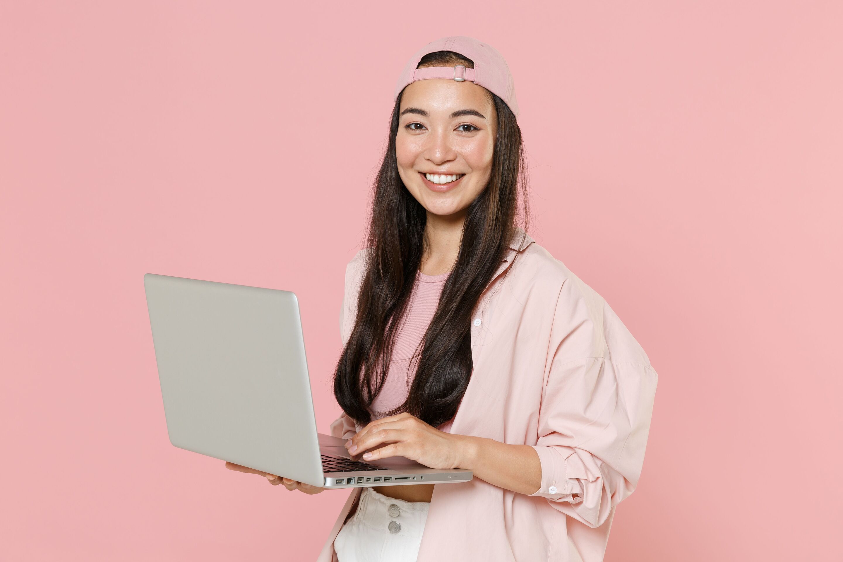 Smiling woman holding a laptop.