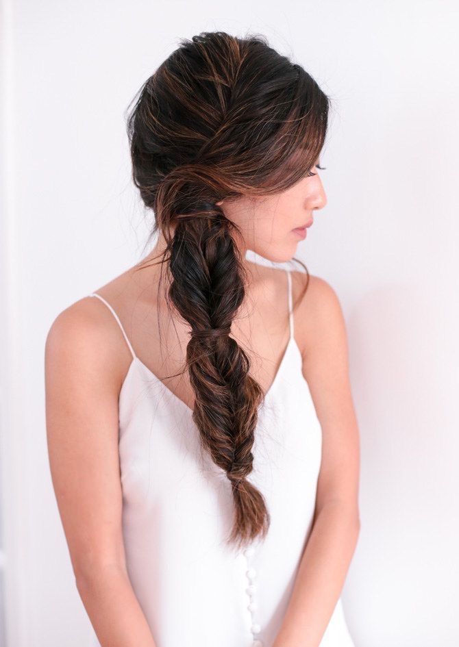 A portrait of woman with fishtail side ponytail.