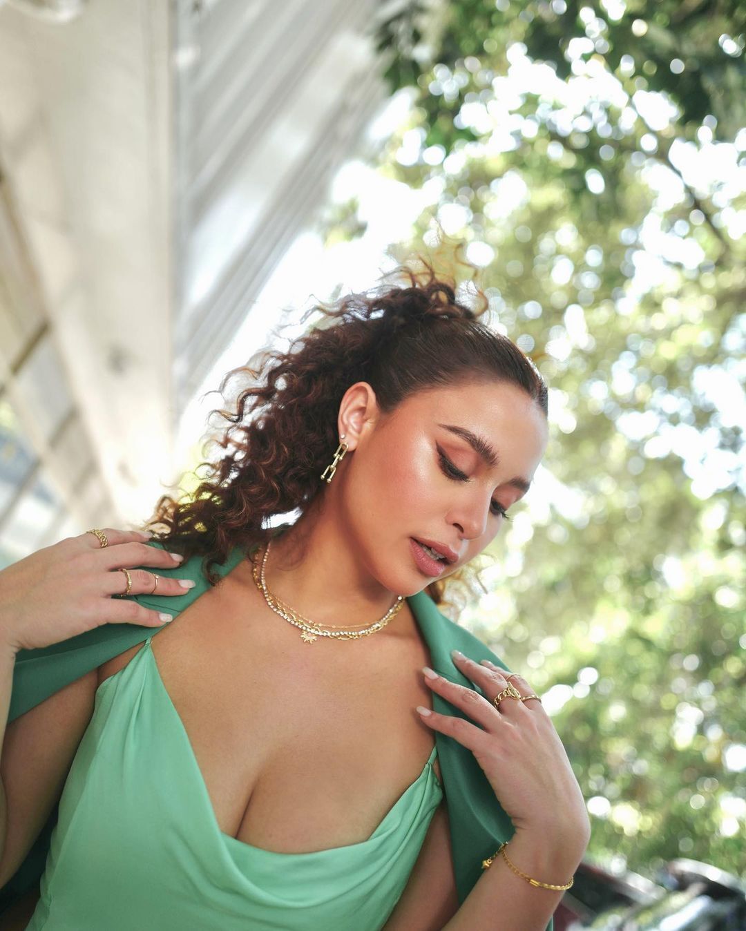 A portrait of Yassi Pressman in green cowl neck dress and green blazer.