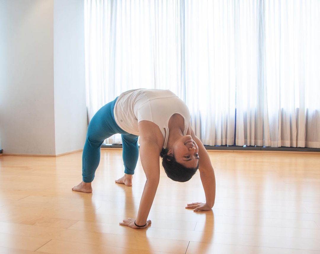 Urban Ashram yoga teacher, Amanda Zabat, is all smiles while doing a Wheel Pose. (Credit: instagram/amandazabat)