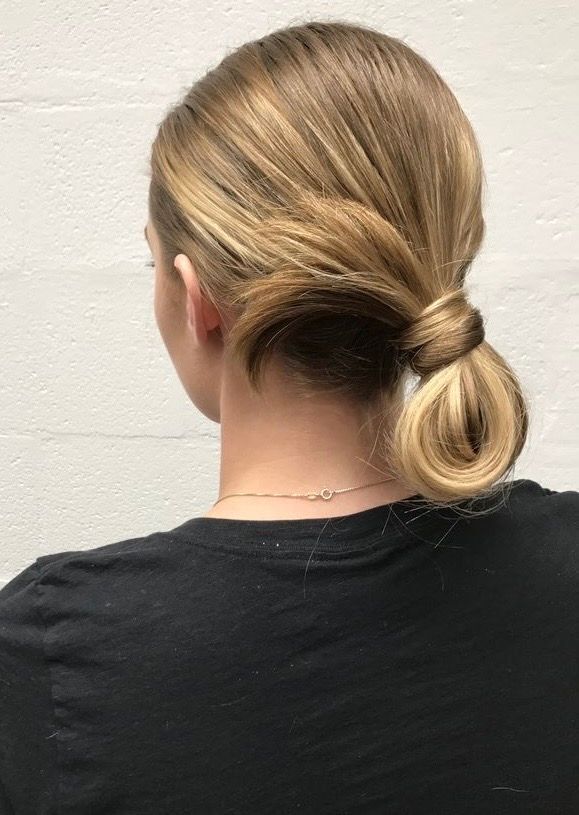 A portrait of woman with blonde, looped ponytail.