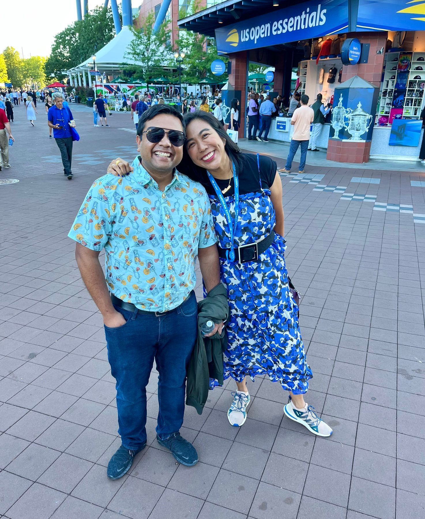 Married Asian couple in casual, printed attire at a sporting event.  