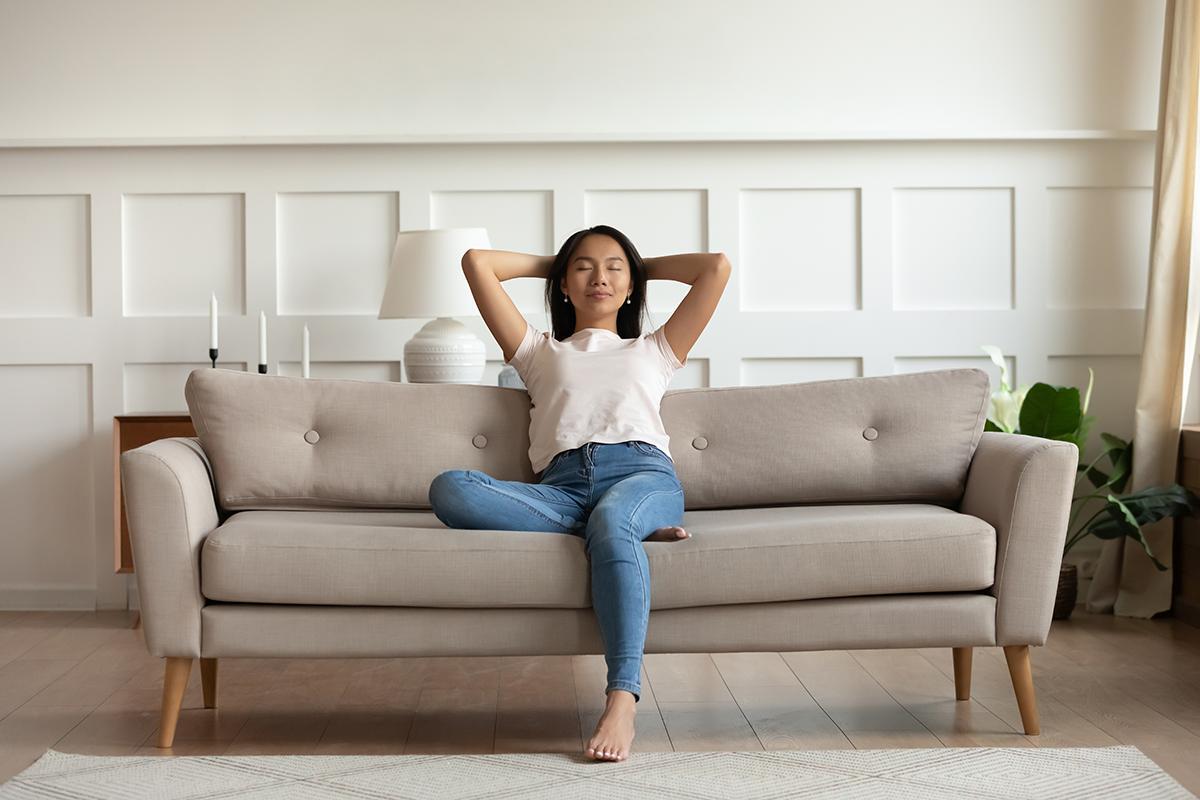 Asian woman peacefully sitting on a couch