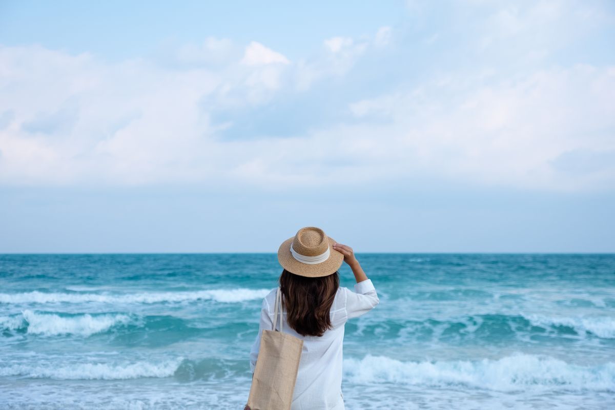 Woman wearing a hat looking at the ocean 