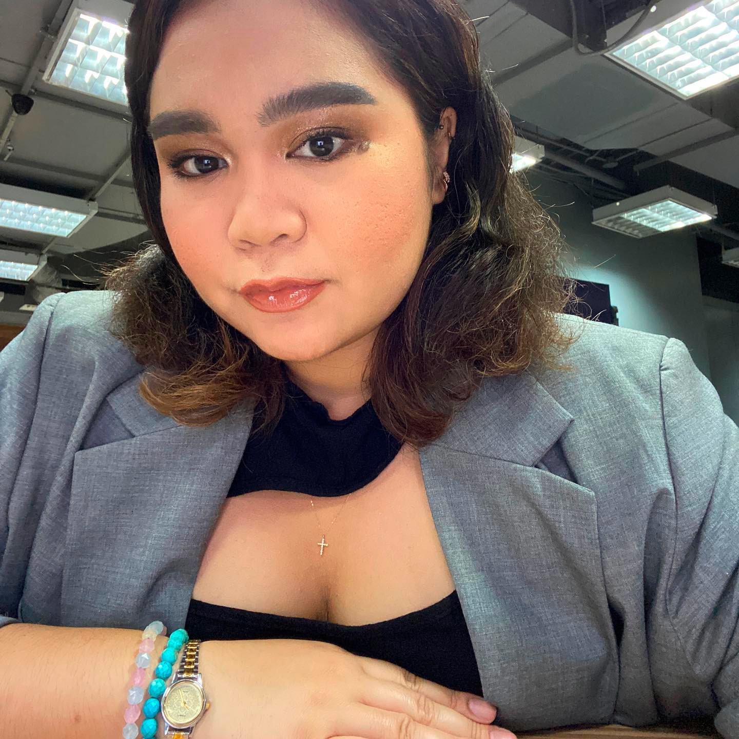 Woman with a resting bitch face wearing a gray blazer.