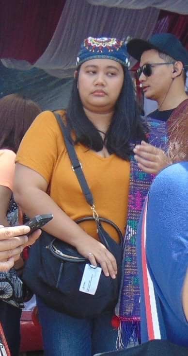 Asian woman wearing a yellow shirt and a bandana.