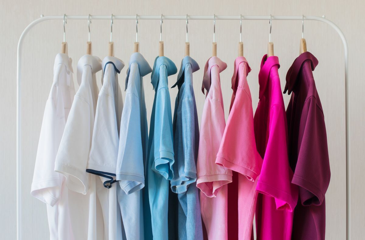 Men’s polo shirts hanging against a white background.