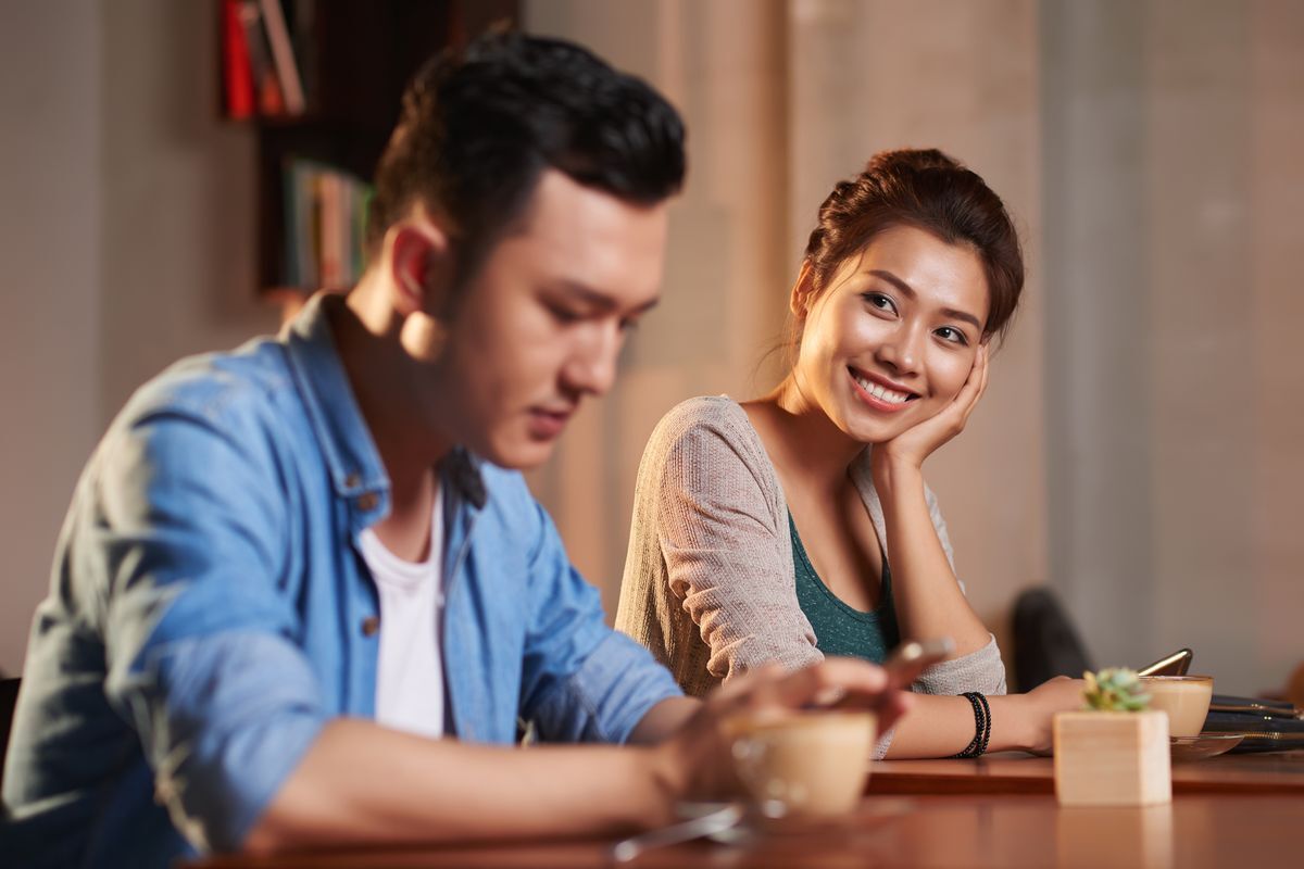 Woman fondly smiling at Asian man 