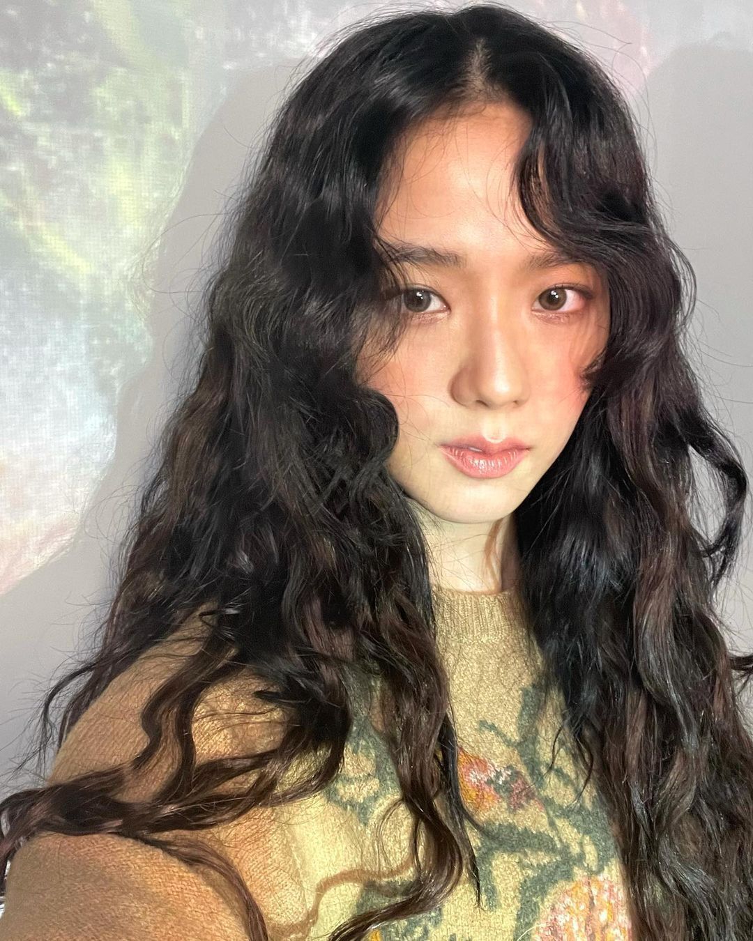 A selfie of a Korean woman with long, curly hair