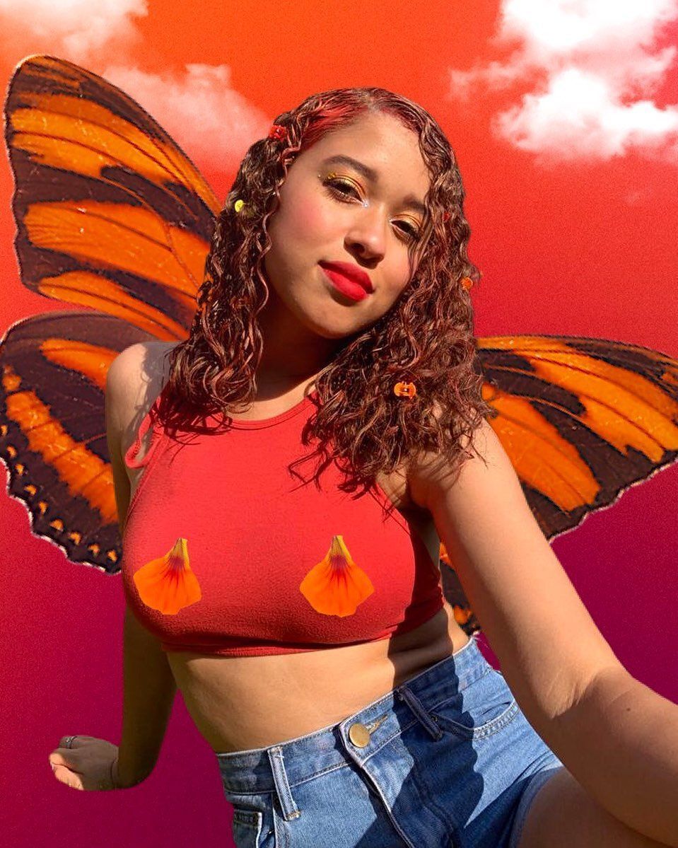 A portrait of woman with curly dyed red hair.