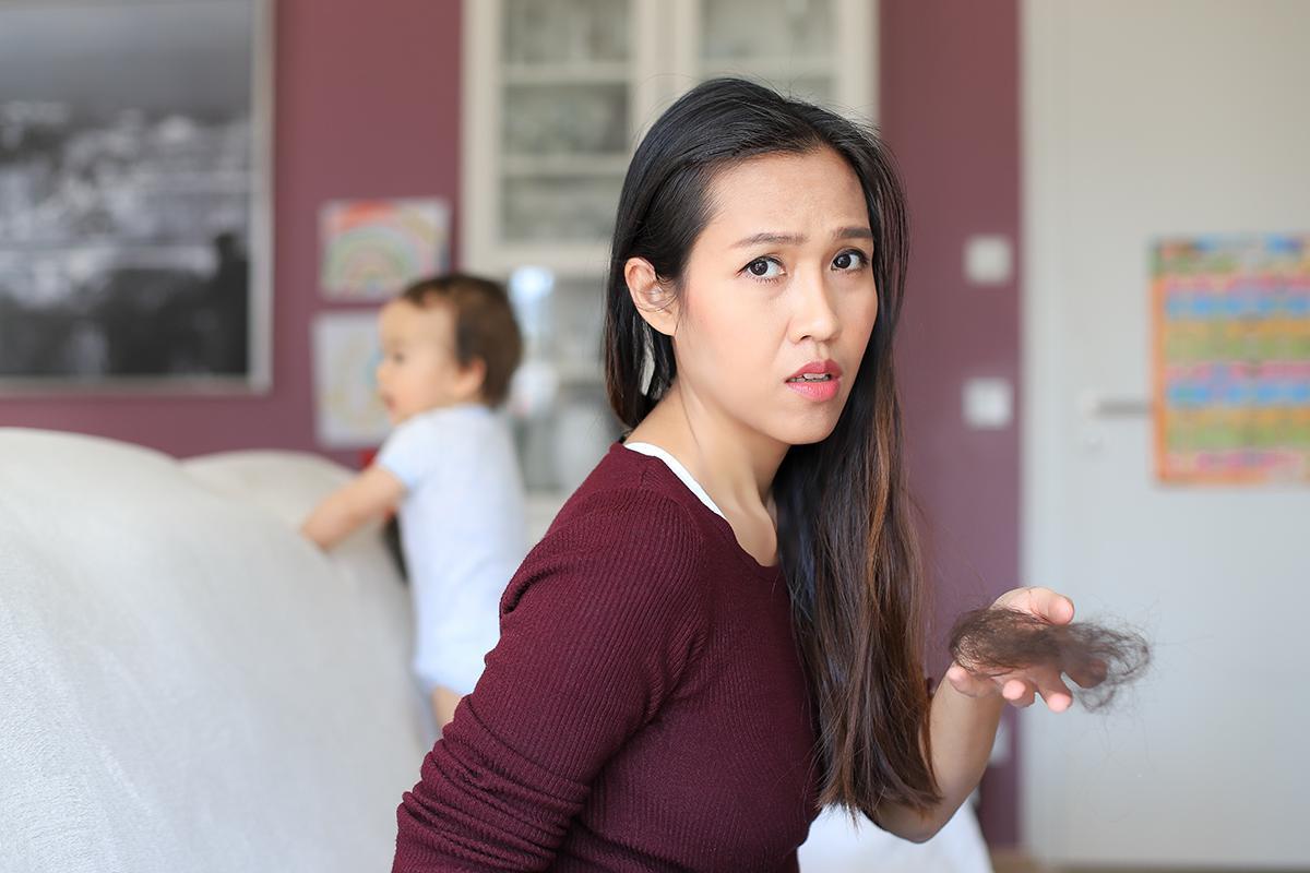 Asian mom holding hair in hand