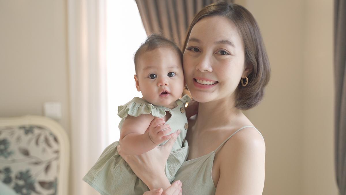 Asian mom with bob carrying baby girl