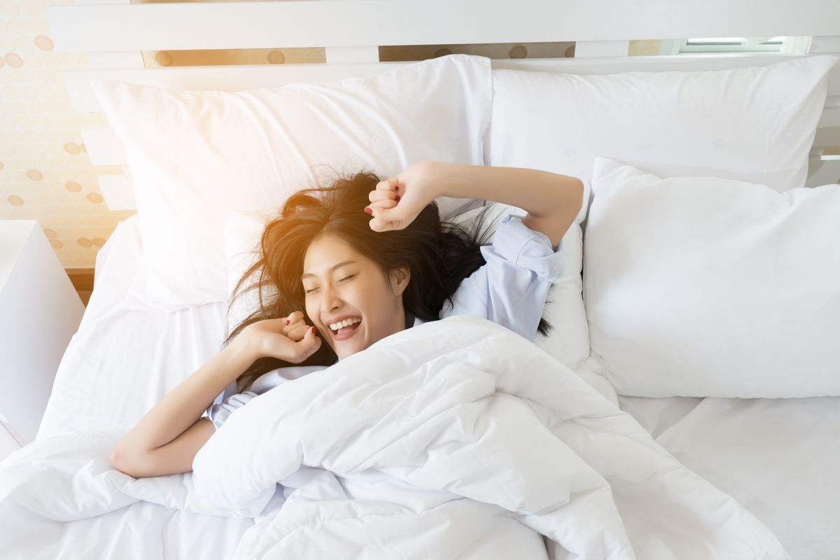 Asian woman happily waking up in the morning. 