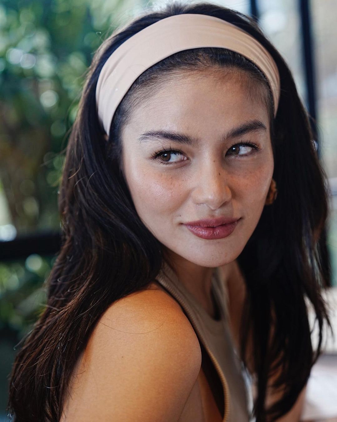 A portrait of Elisse Joson with a crème headband and simple makeup.