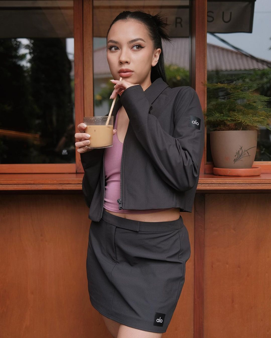 A portrait of woman with matching workout sets drinking coffee. 