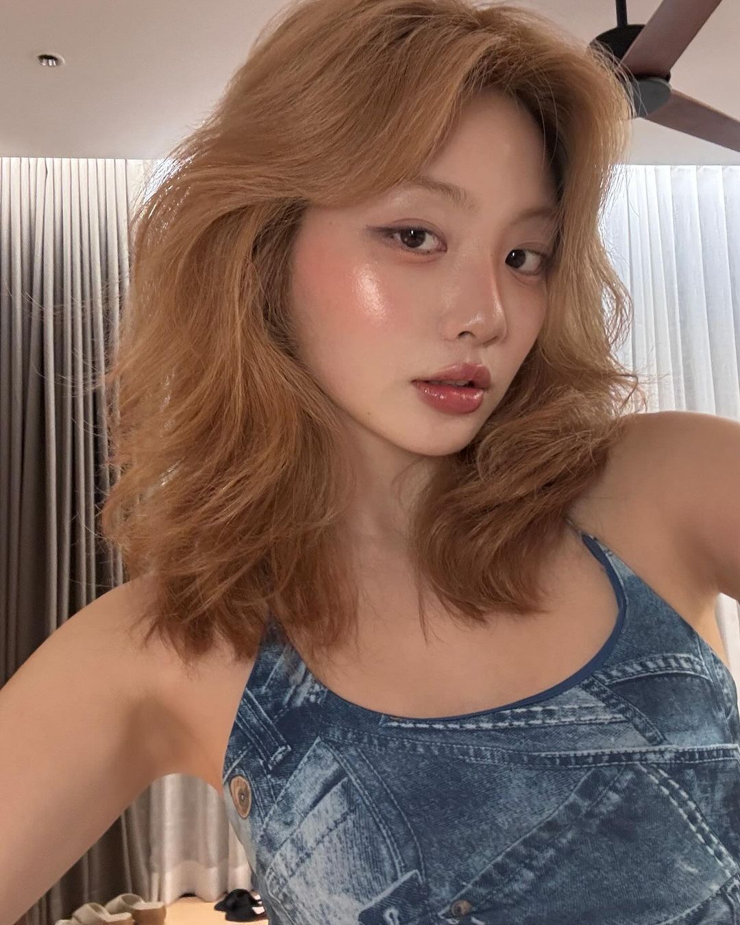 A portrait of woman with dewy makeup and shaggy hair.