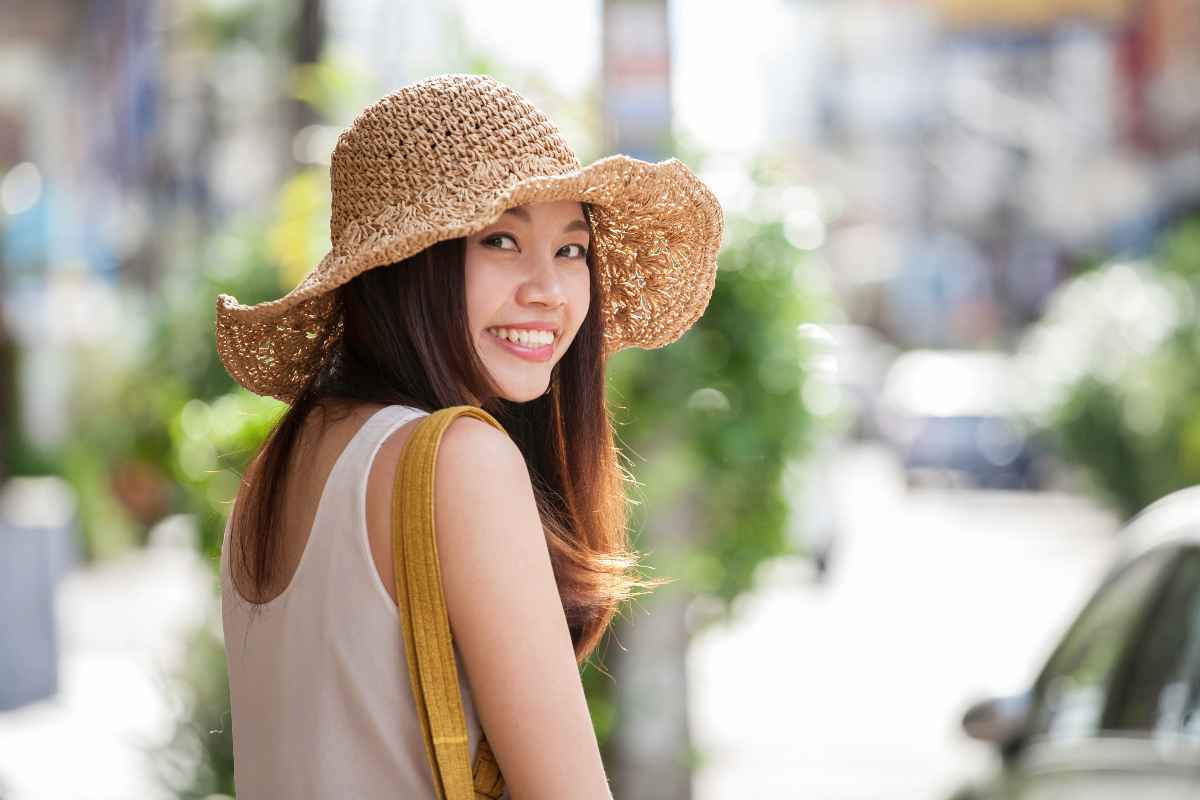 Smiling woman wearing hat strolling in the city.