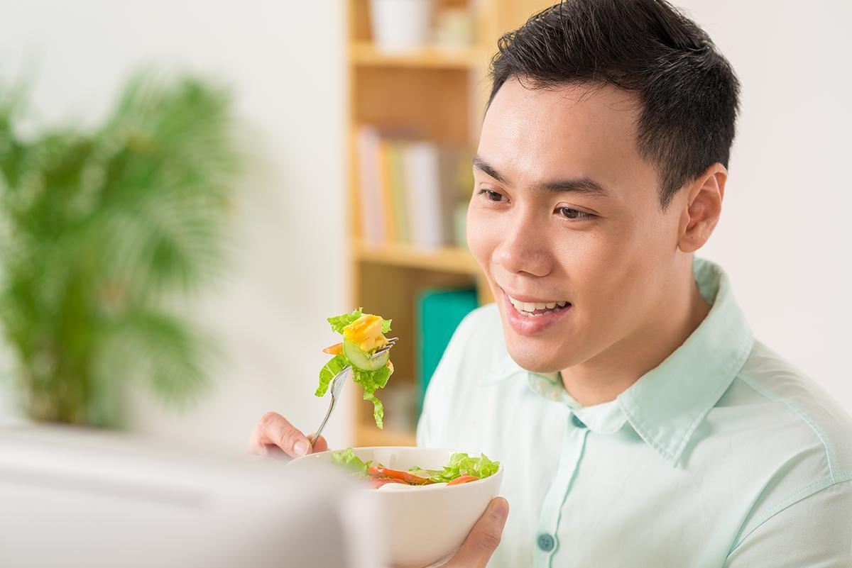 A young man eats a salad