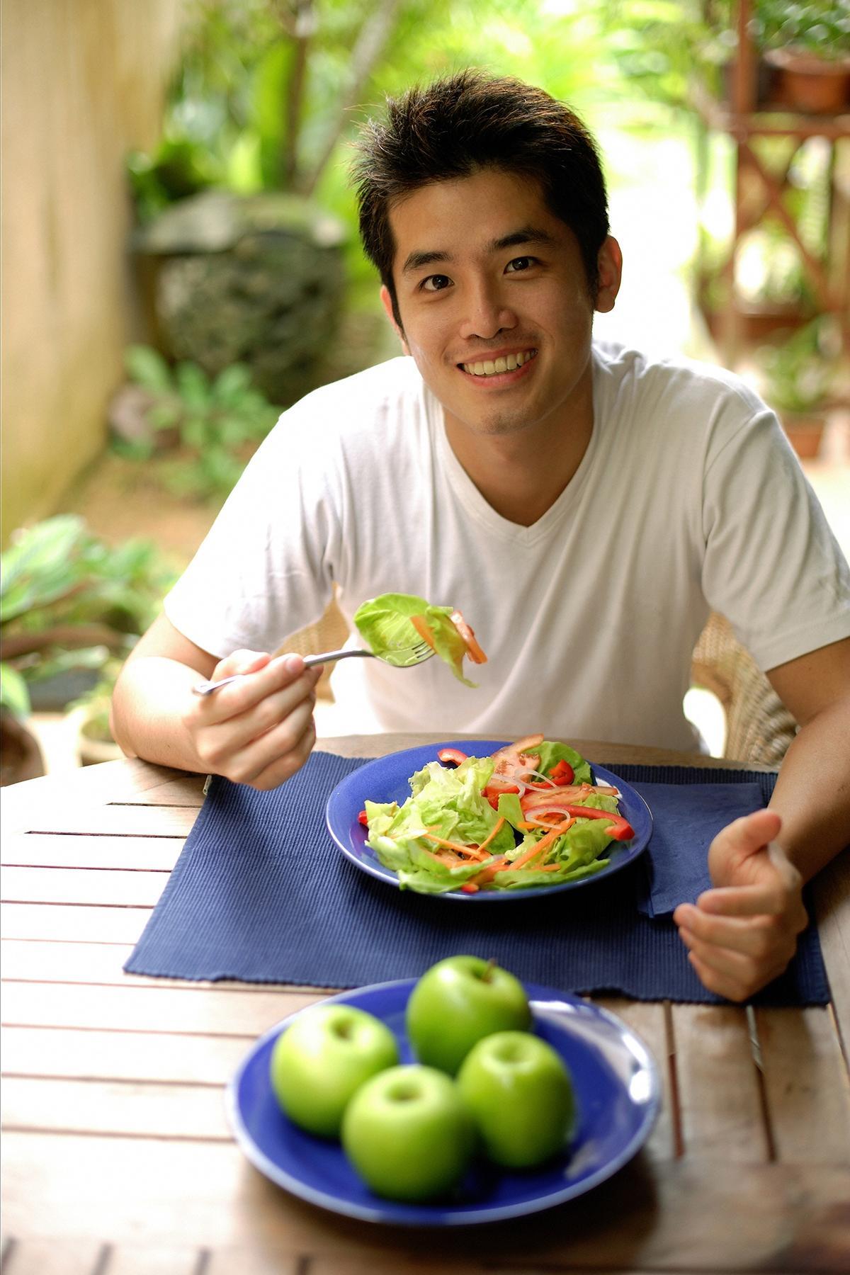 Asian man eating salad  