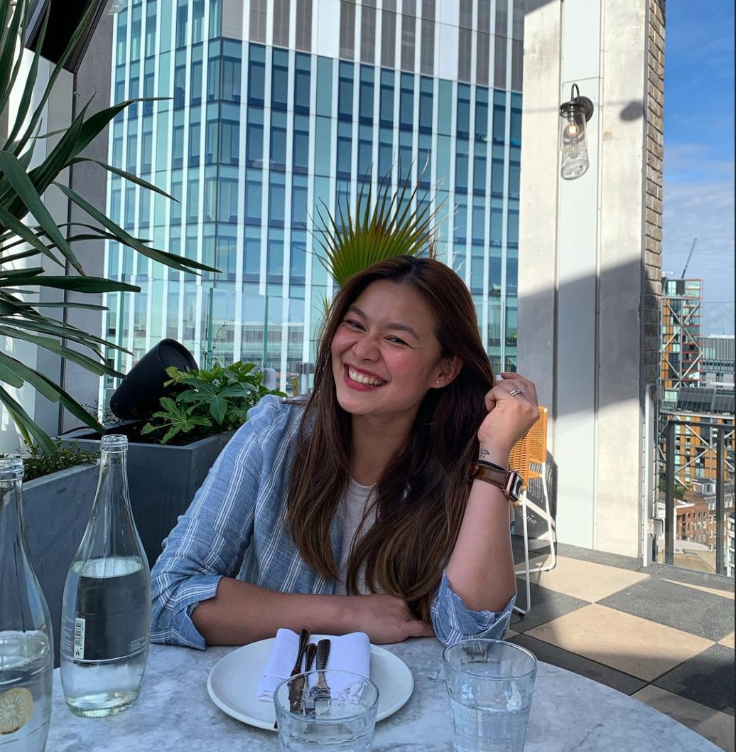Happy Asian woman with long hair having an al fresco meal. 