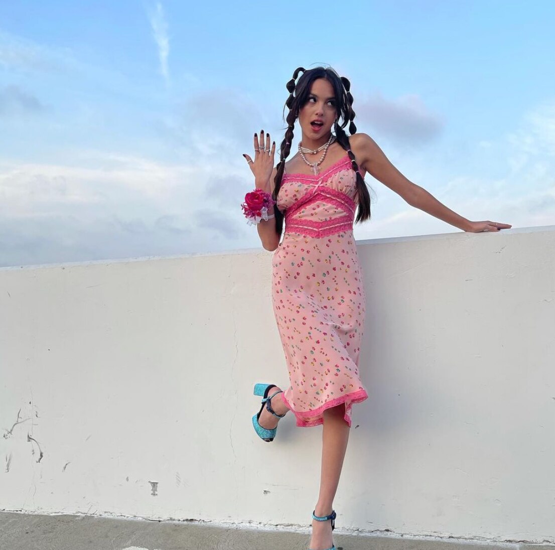 Teenager in pink dress, pigtails, and blue platform shoes