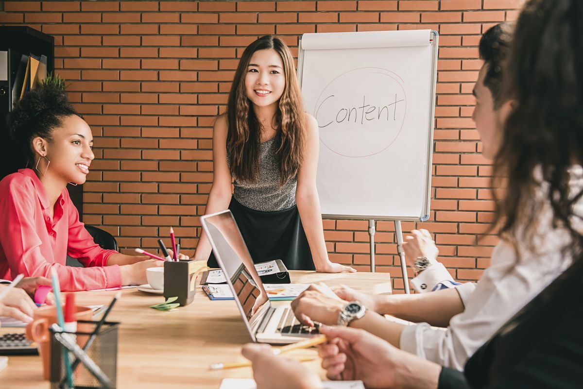 Asian woman leading a meeting with her colleagues