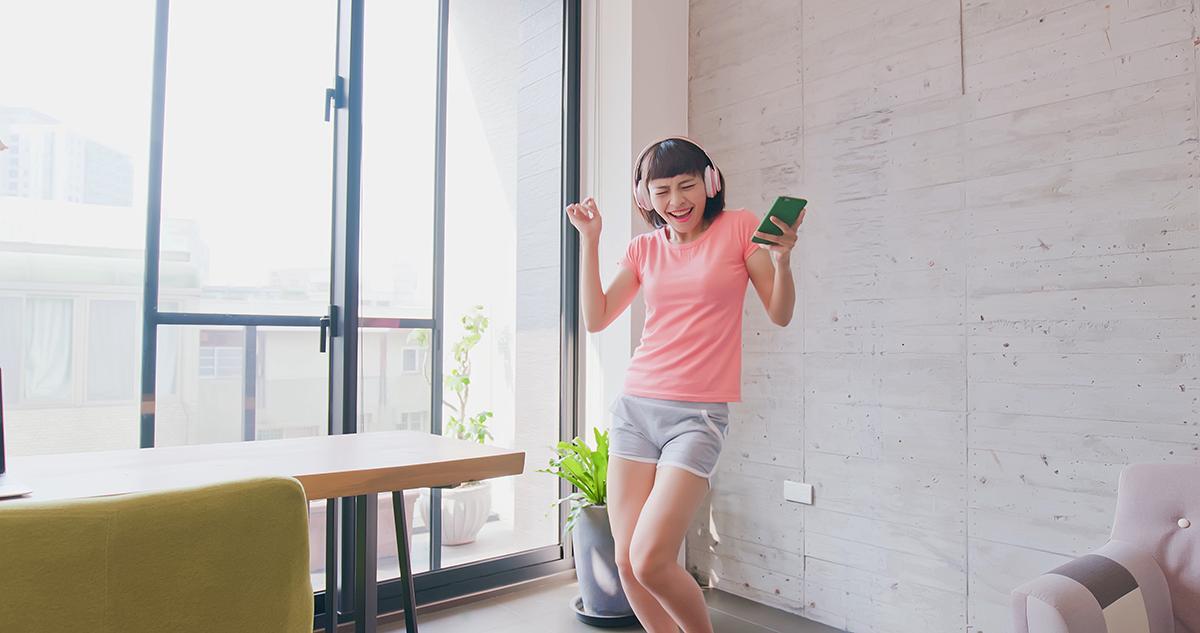 Asian woman listening to music at home 