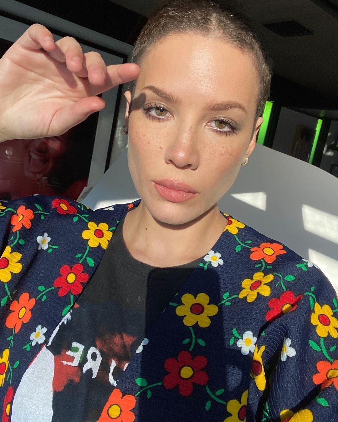 Halsey with a buzz cut wearing a floral sweater