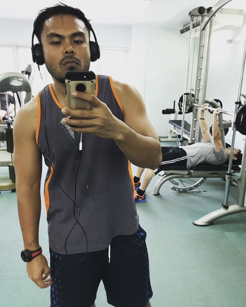 Asian man taking a gym selfie