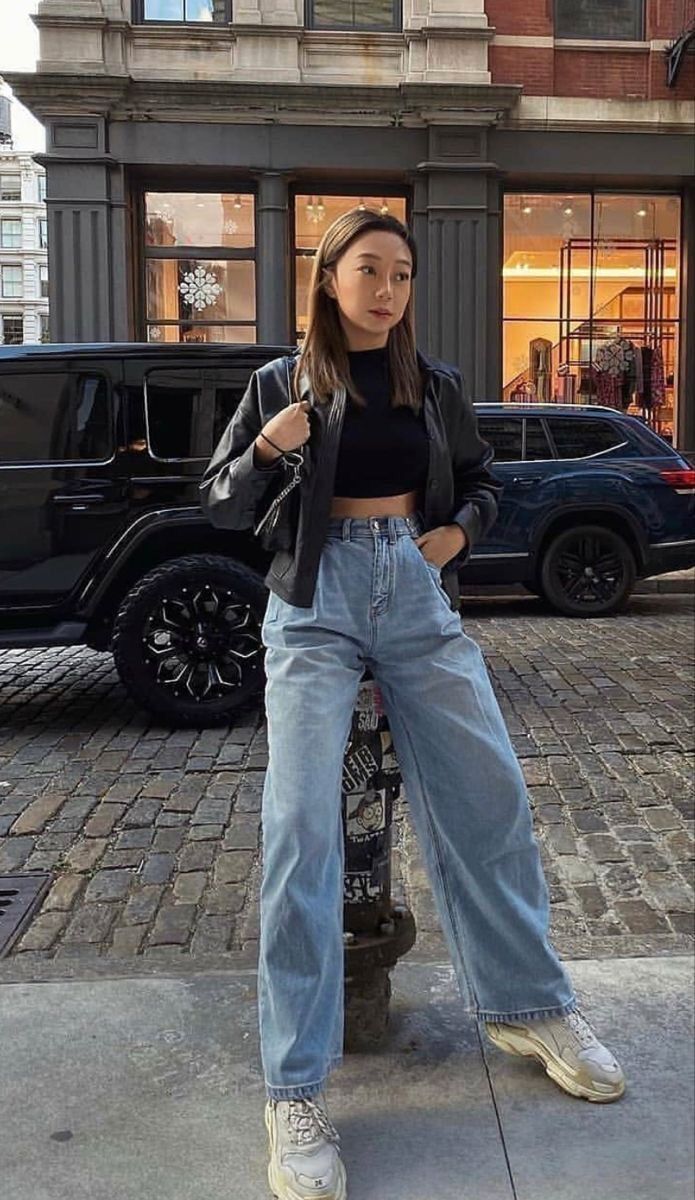 A portrait of woman wearing black crop top and leather jacket.