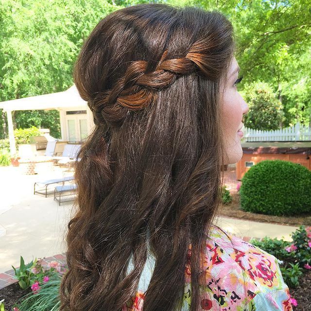 Woman with half-up French braid wearing floral top.