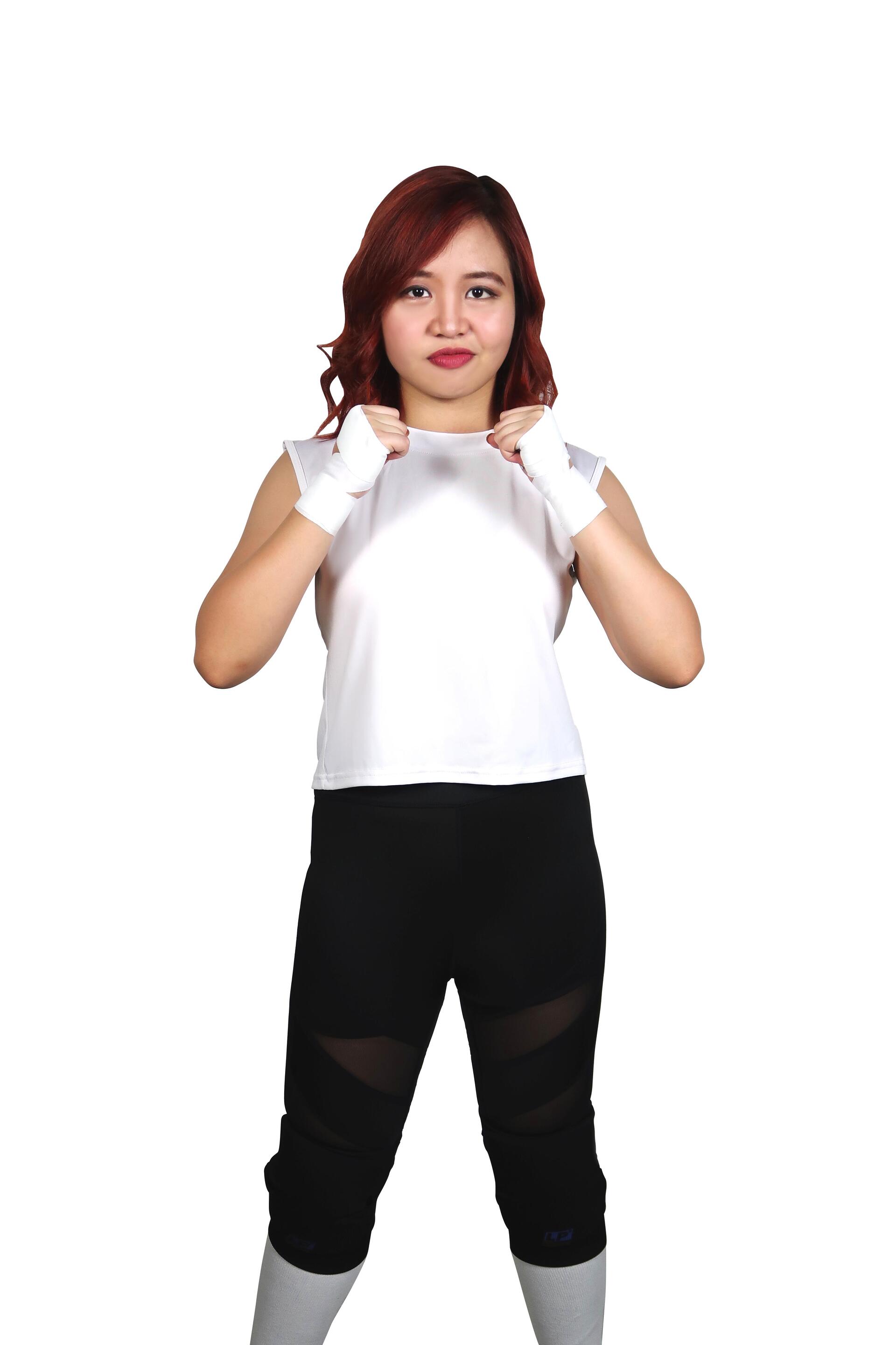 A woman in wrestling attire putting her fists in front of her chest 