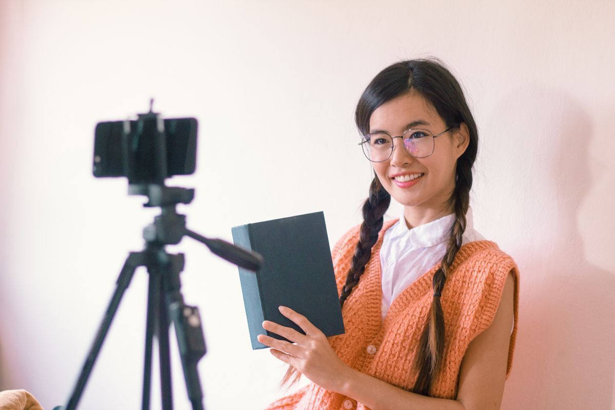 Asian student wearing braids talking in front of the camera.