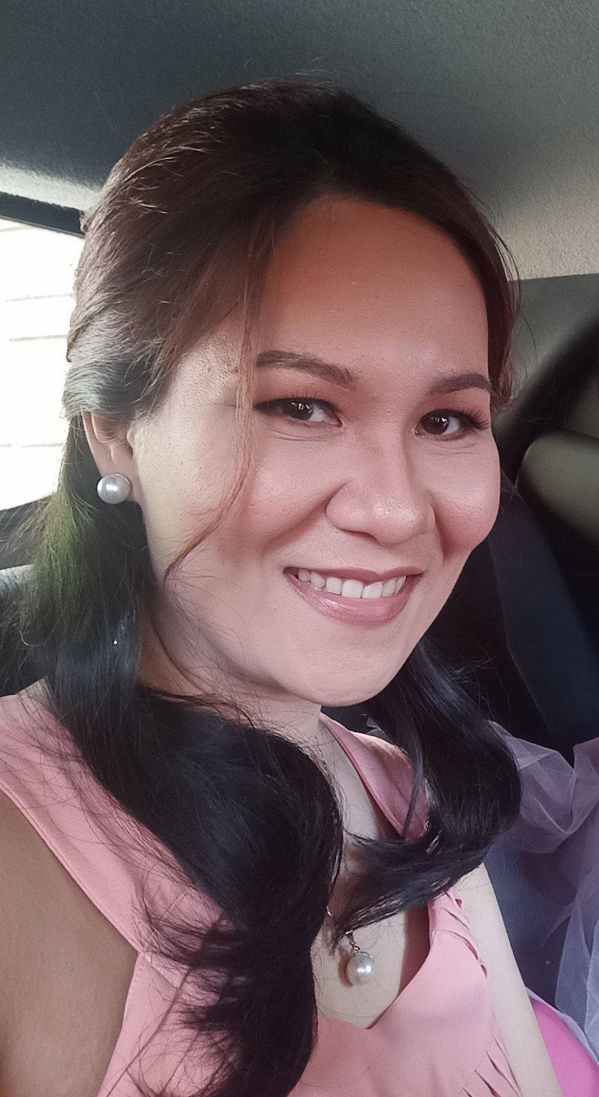 A woman in a pink dress smiling at the camera