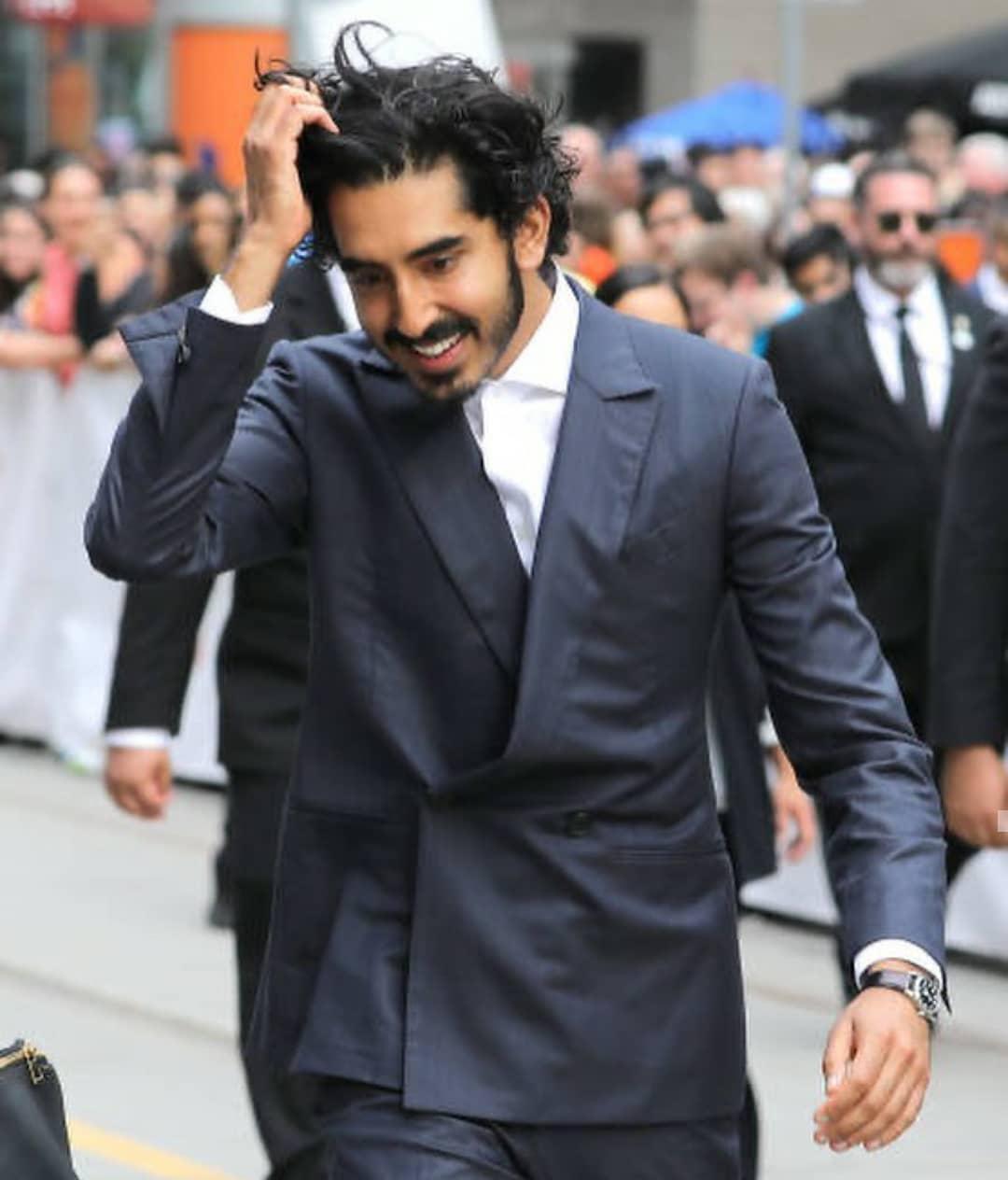 Dev Patel in a gray suit