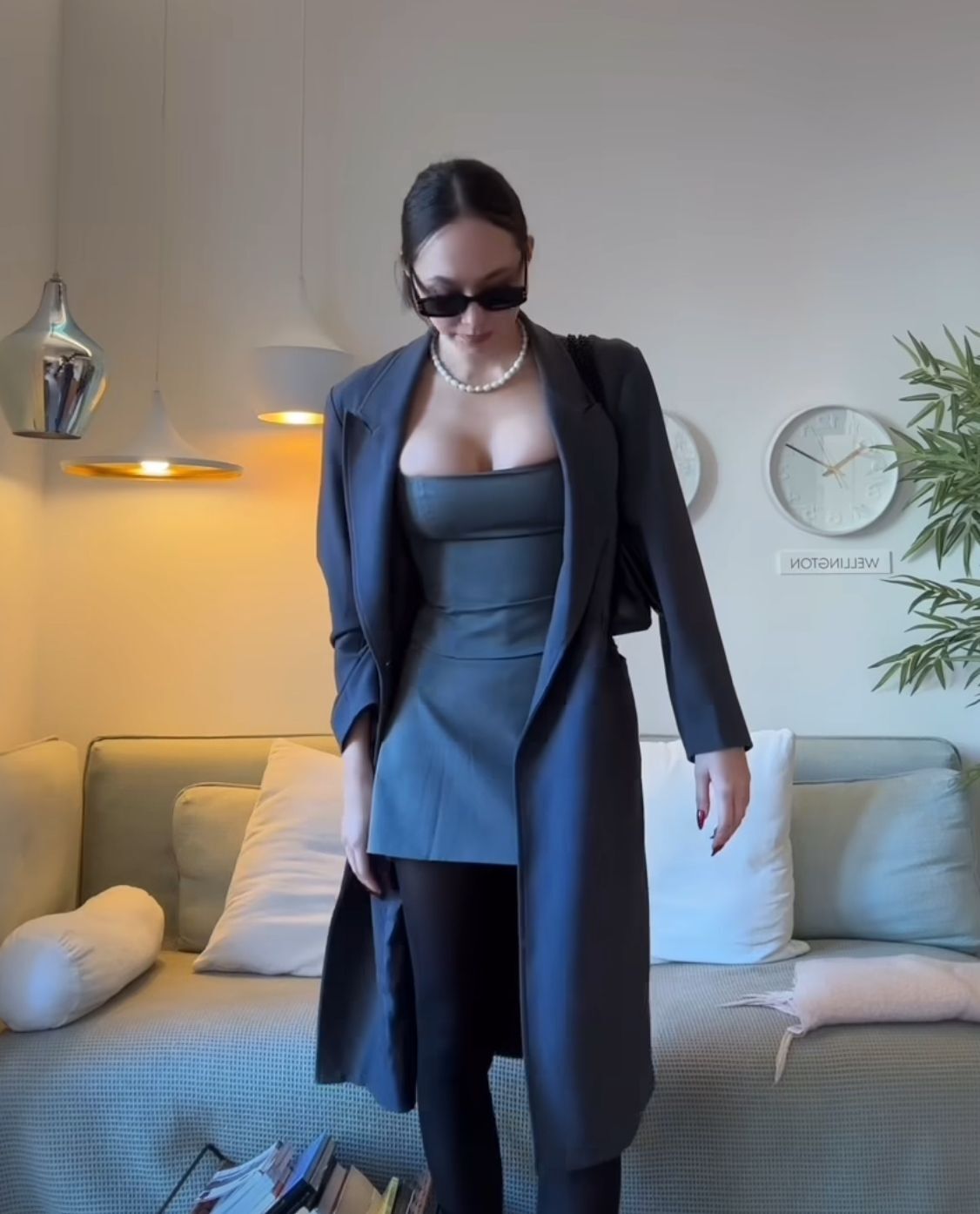 Asian woman wearing a gray tube top, a gray coat, and a gray skirt as office wear.