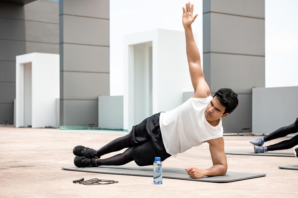 Asian man working out on a condominium rooftop.