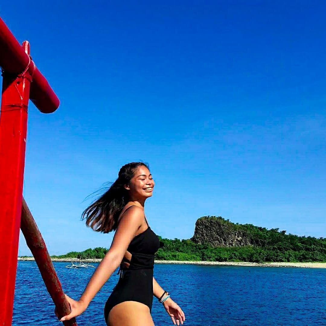 Asian girl in black swimsuit in the ocean.