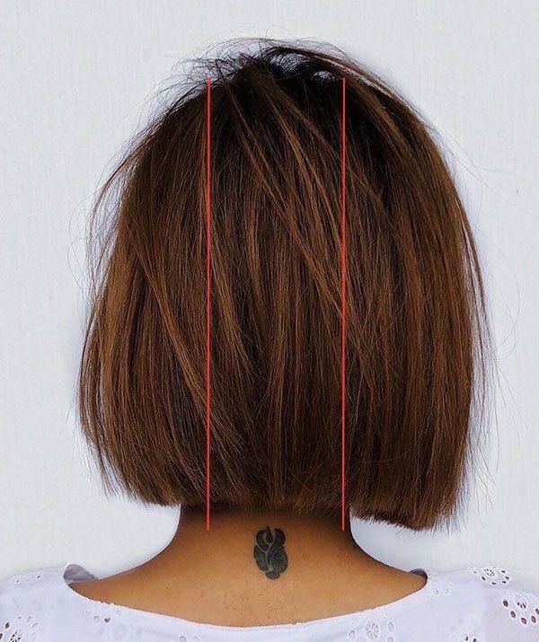 Back view of a woman with a bob, with two red lines drawn on her hair