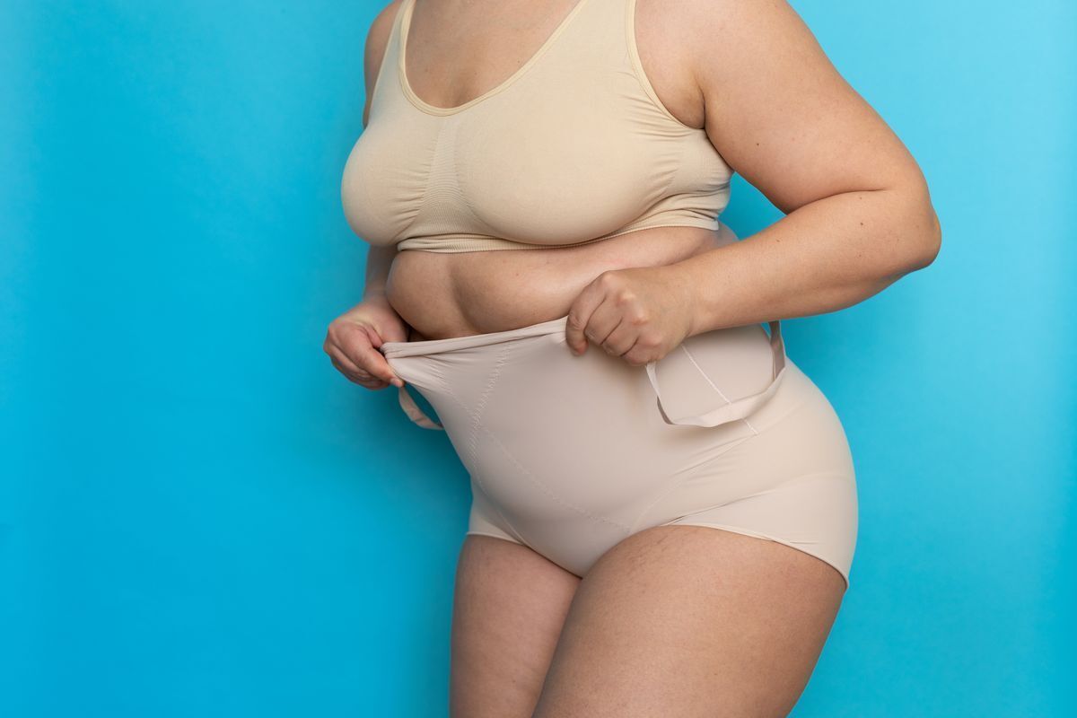 Plus size Asian wearing beige shapewear.