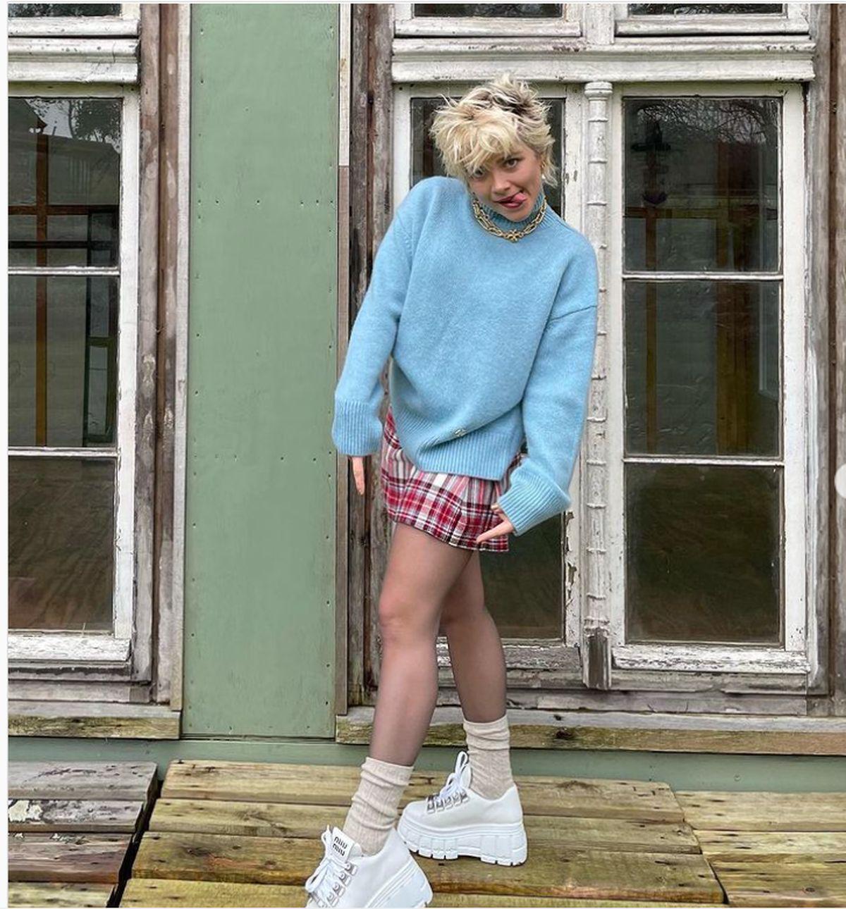 Florence Pugh in blue sweater and plaid skirt 