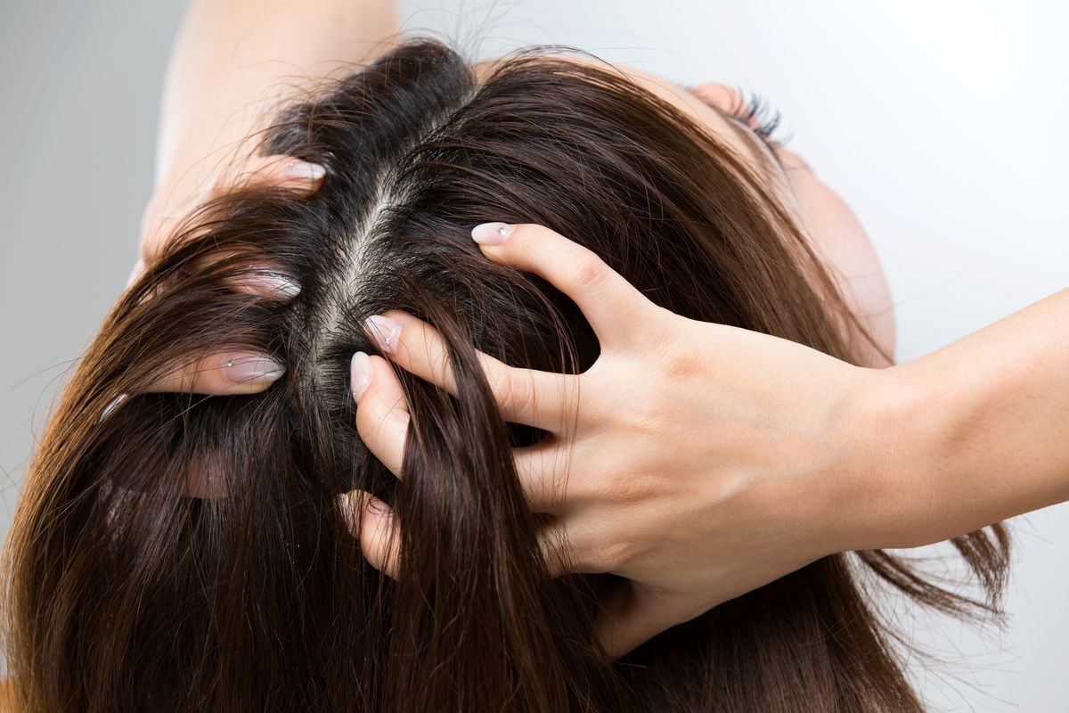Woman massaging her scalp with her fingers.